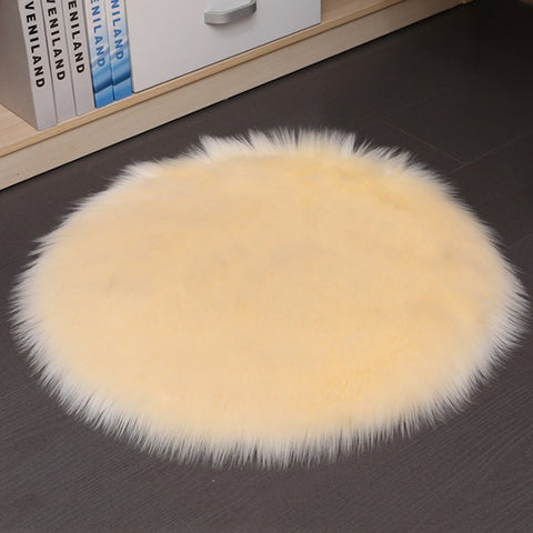 Round beige rug on a dark floor with books in the background