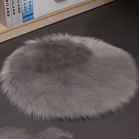 Gray fluffy rug on a dark floor with books in the background