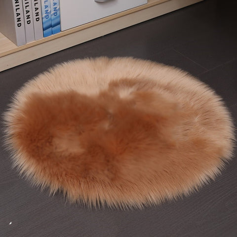 Round beige fur rug on a dark surface with books in the background