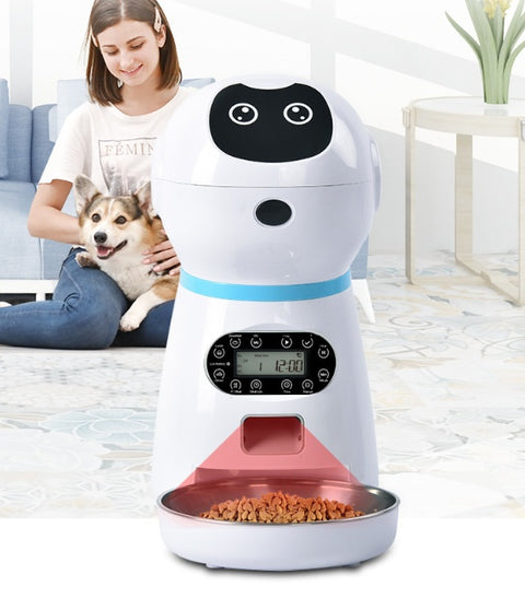 Pet food dispenser with a digital display and bowl, placed in a home setting with a person and dog.
