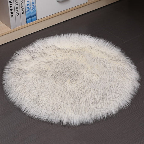 Round white fluffy rug on a dark floor with books in the background