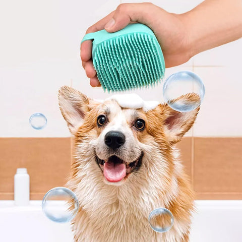 Dog being bathed with a green silicone brush, surrounded by bubbles in a bathroom setting.